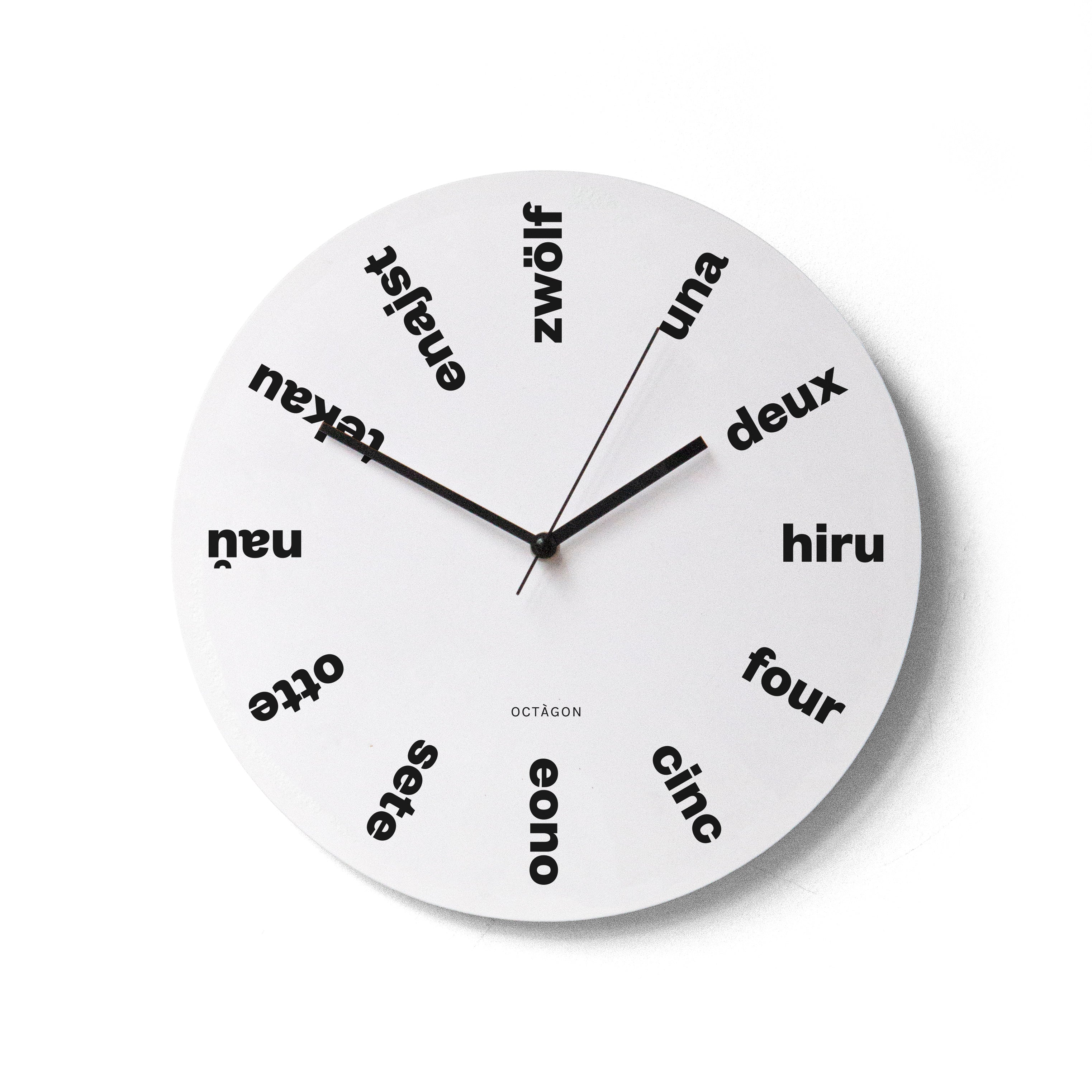 "Babel" wall clock. White base, typography and clock hands black colour.
