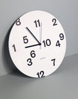 "Octavi Serra" wall clock. White base, typography and clock hands black colour.