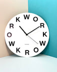 "Work" clock on a colored wall | Reloj "Work" en una pared de colores. | Rellotge "Work" en una paret de colors.