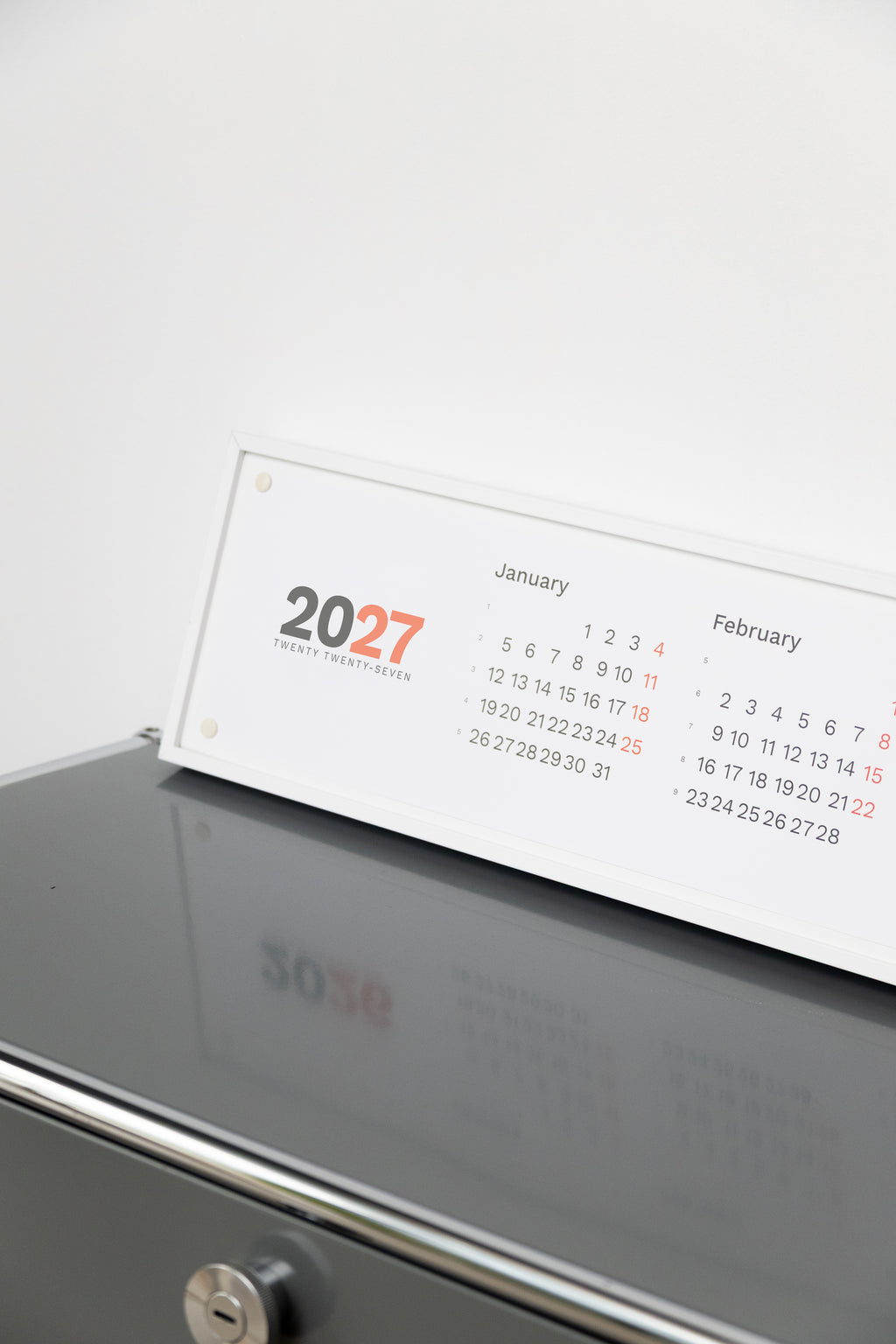 2027 Horizontal Calendar by Octàgon Design. The calendar on a office shelf.