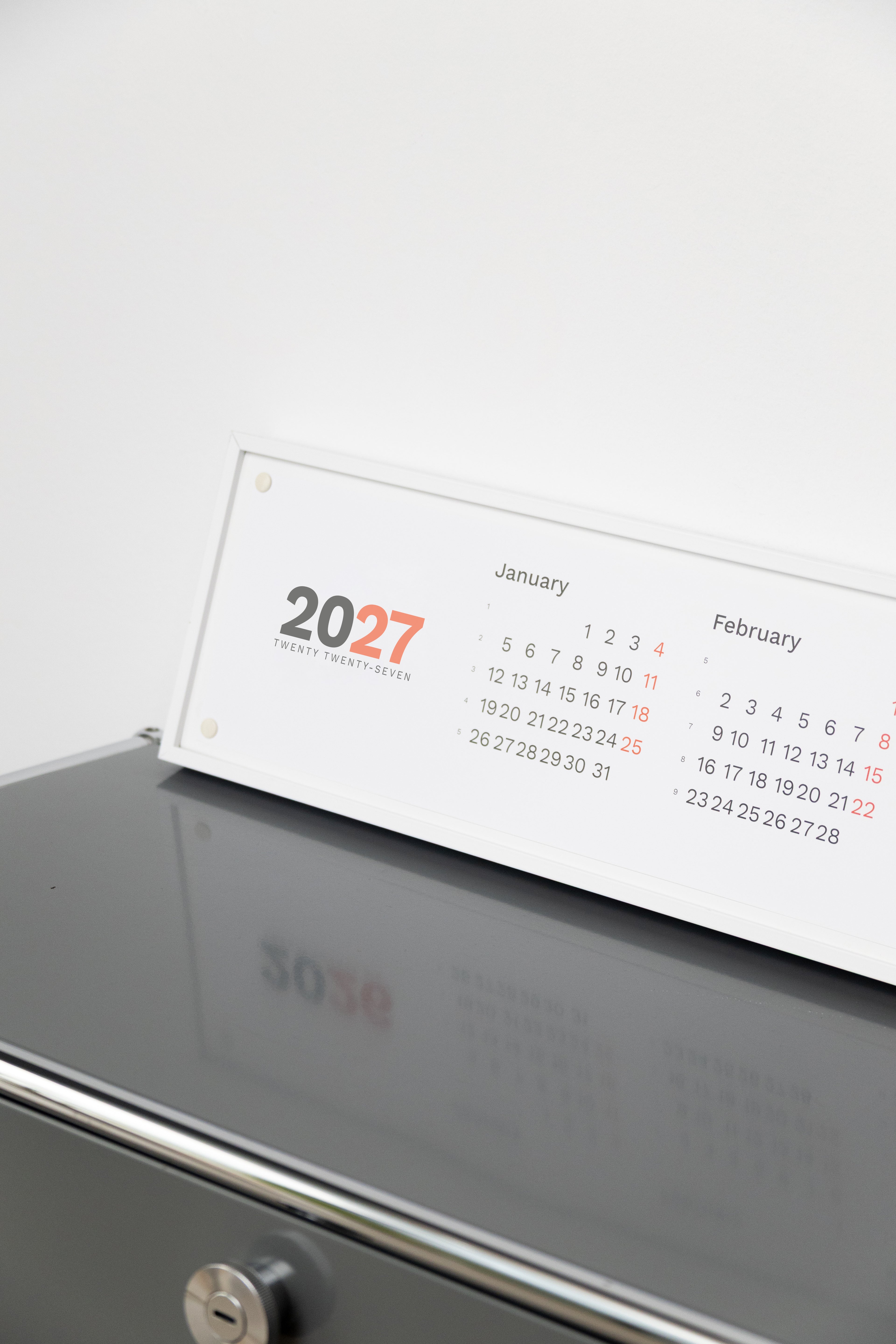 2027 Horizontal Calendar by Octàgon Design. The calendar on a office shelf.