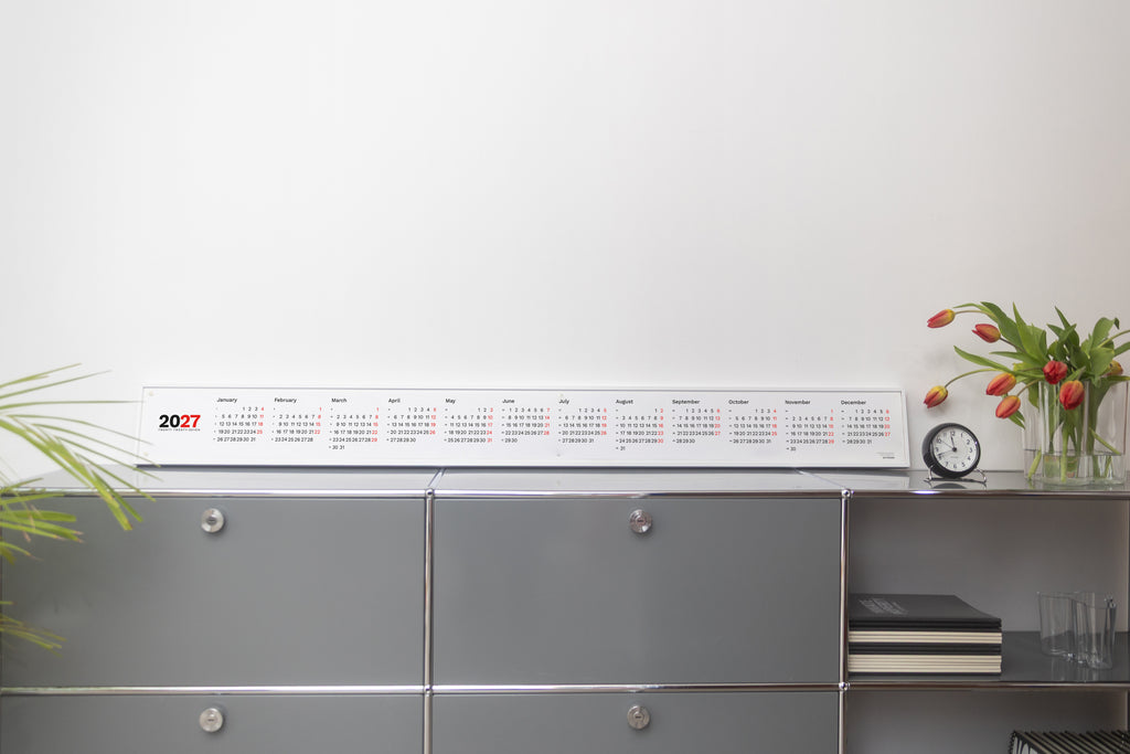 2027 Horizontal Calendar by Octàgon Design. The calendar placed on top of a piece of USM furniture.