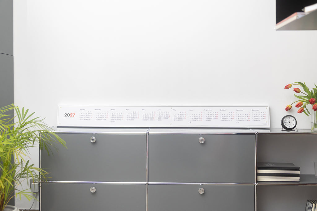 2027 Horizontal Calendar by Octàgon Design. The calendar placed on top of a piece of USM furniture.