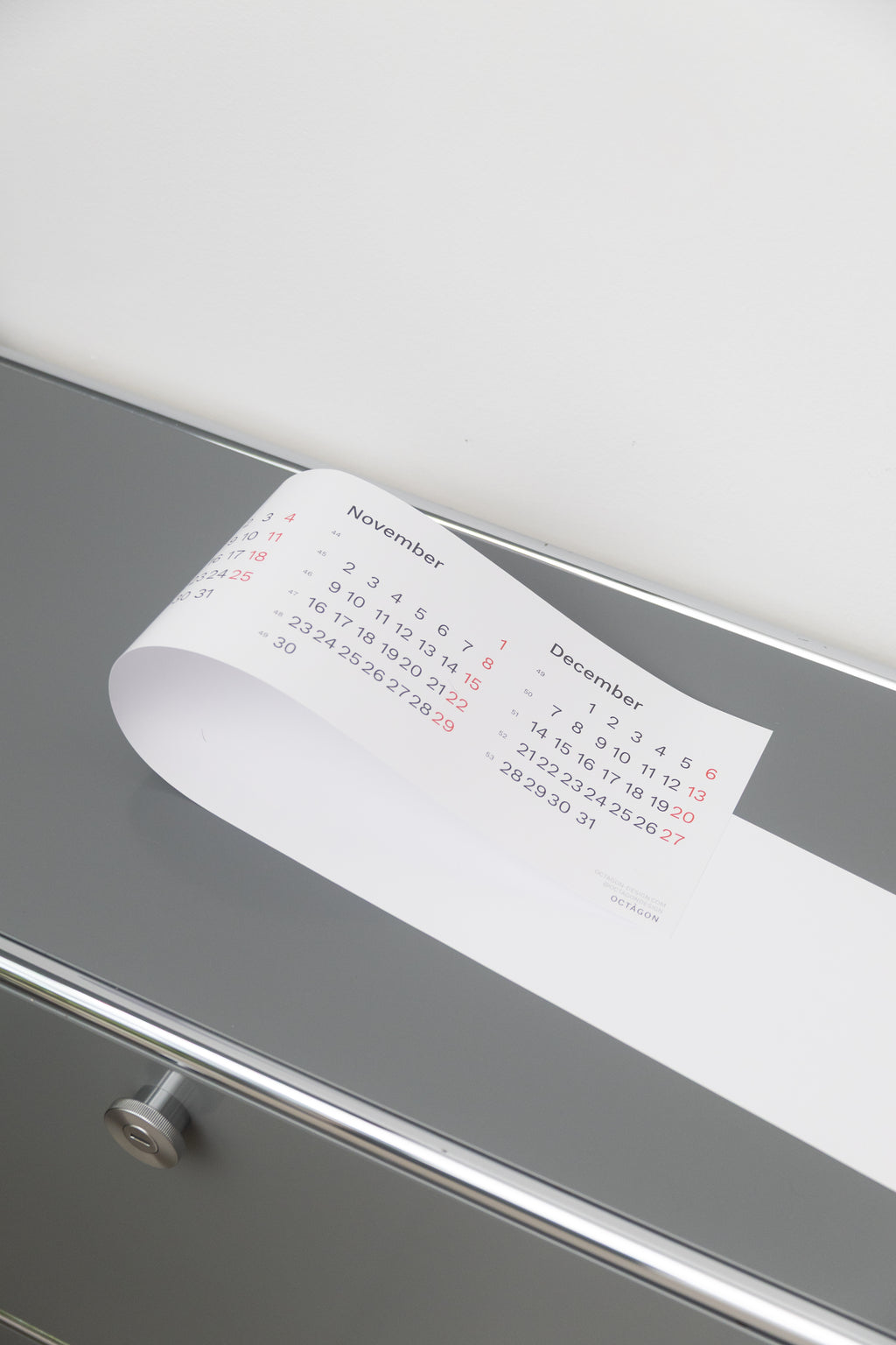 2027 Horizontal Calendar by Octàgon Design. The calendar placed on top of a piece of USM furniture.