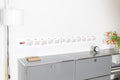 2027 Horizontal Calendar by Octàgon Design. The calendar placed on top of a piece of USM furniture and besides the Arne Jacobsen clock and Mila lamp