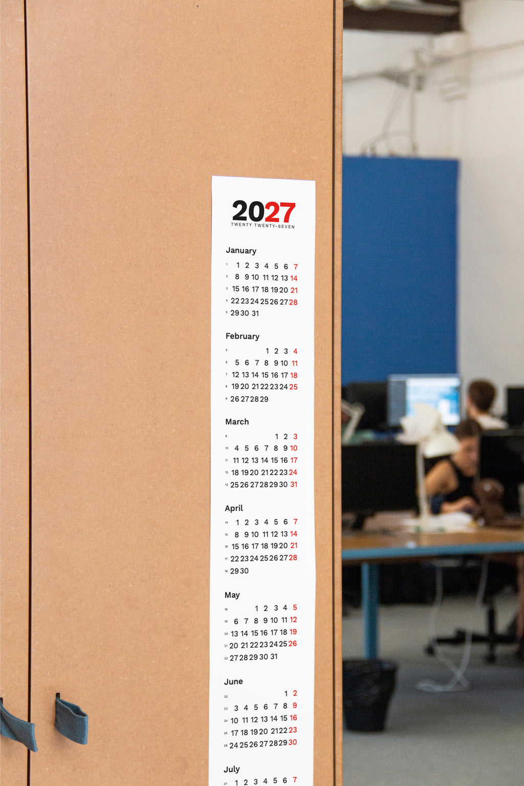 2027 Vertical Calendar by Octàgon Design. The calendar placed in an Office atmosphere.