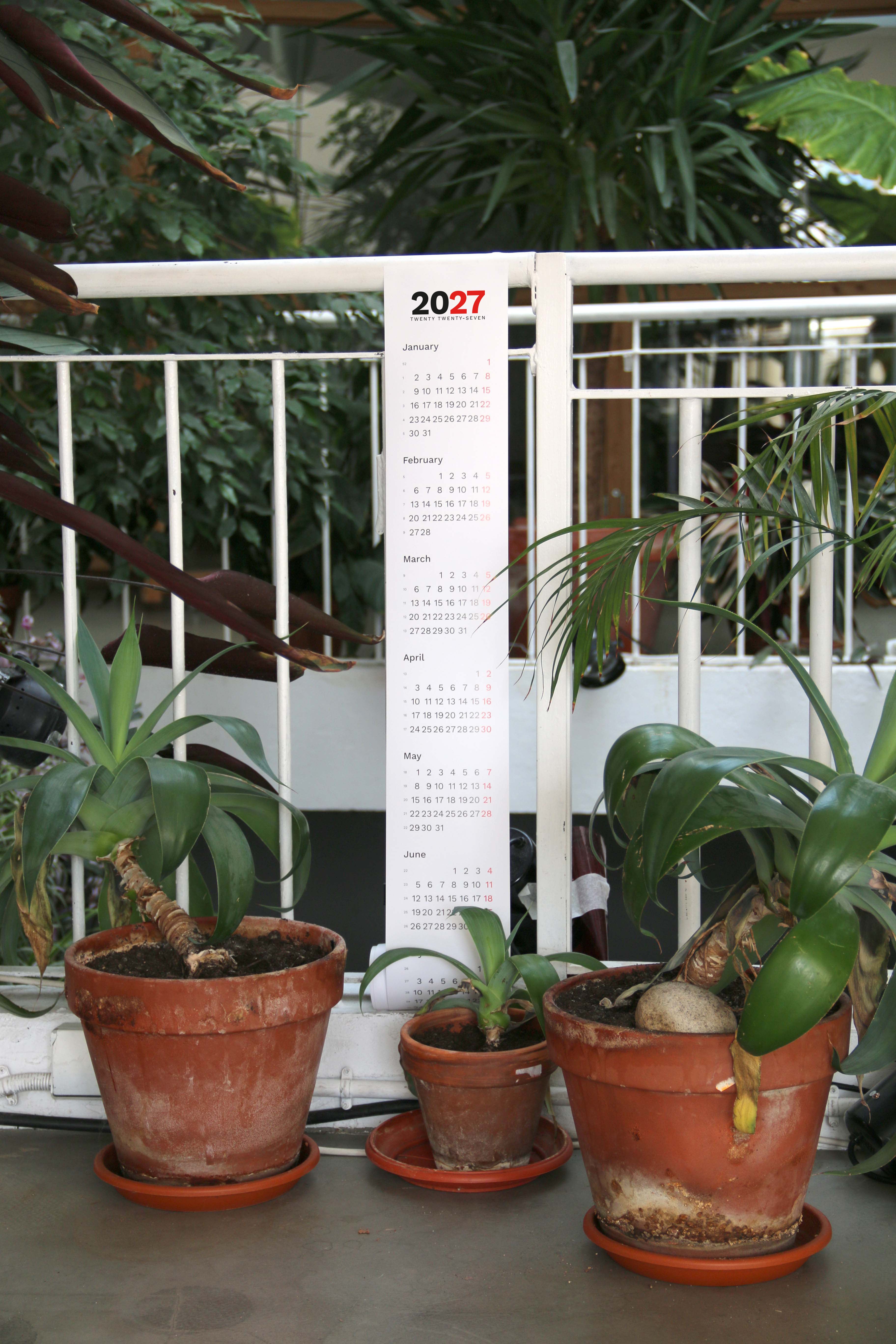 2027 Vertical Calendar by Octàgon Design. The calendar hanging on the balcony railing.