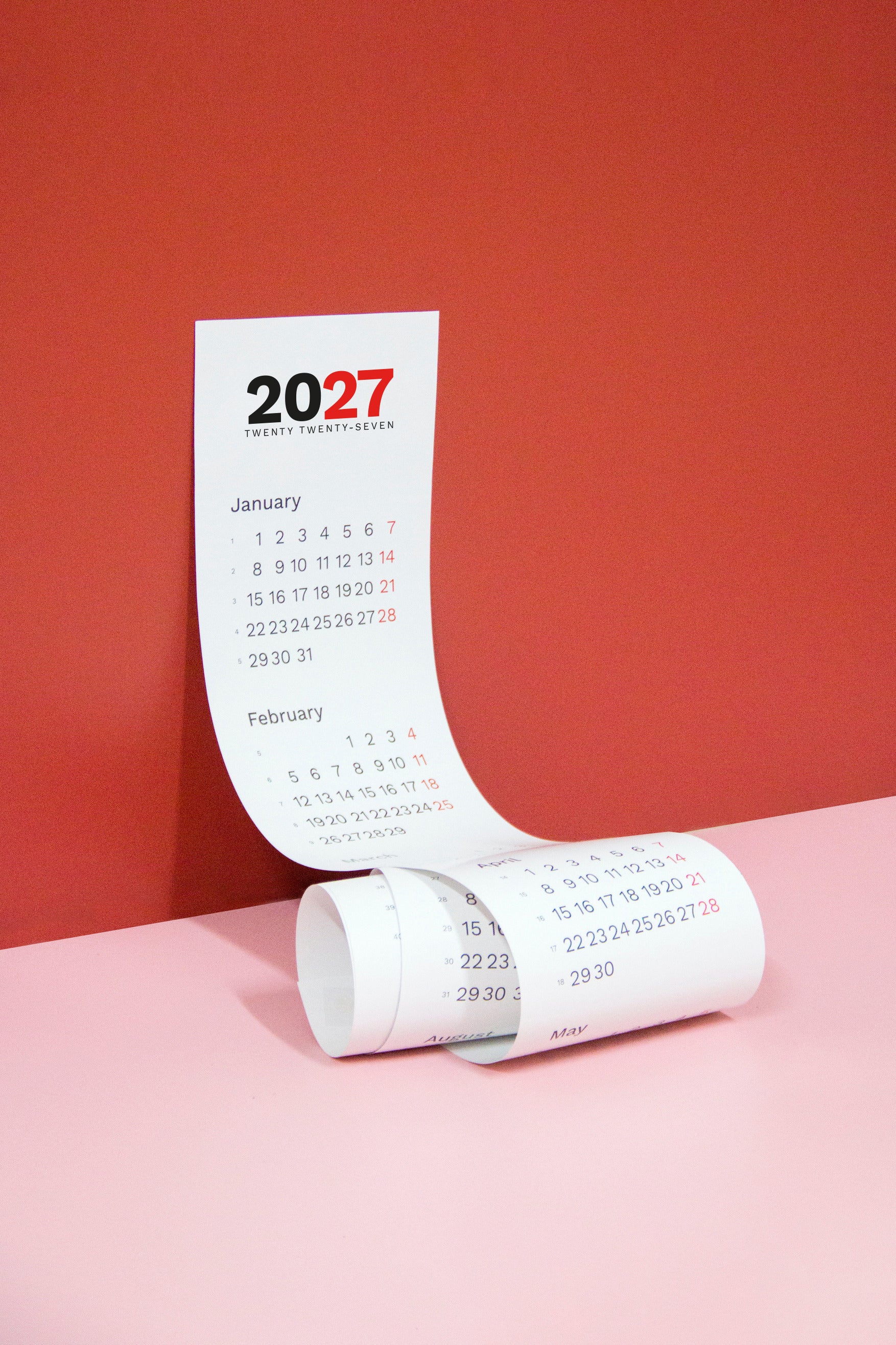 2027 Vertical Calendar by Octàgon Design. The calendar hanging on a red wall.