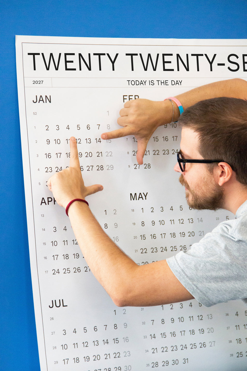 2027 Wall Calendar by Octàgon Design. Date Markers. A man planning and organizing events.
