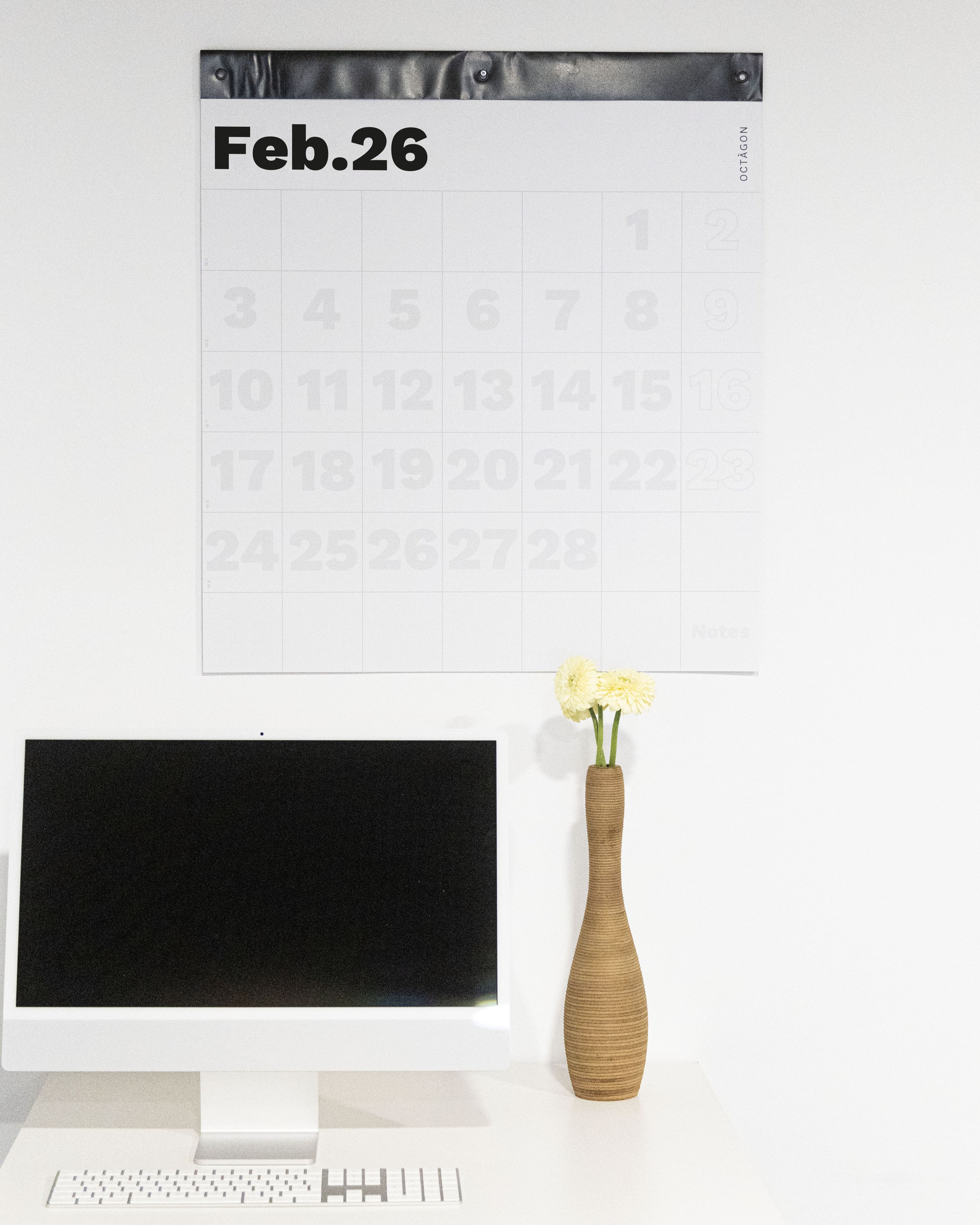 2026 Octàgon Design Giant Wall Planner on a white wall above a desk with a computer and vase.