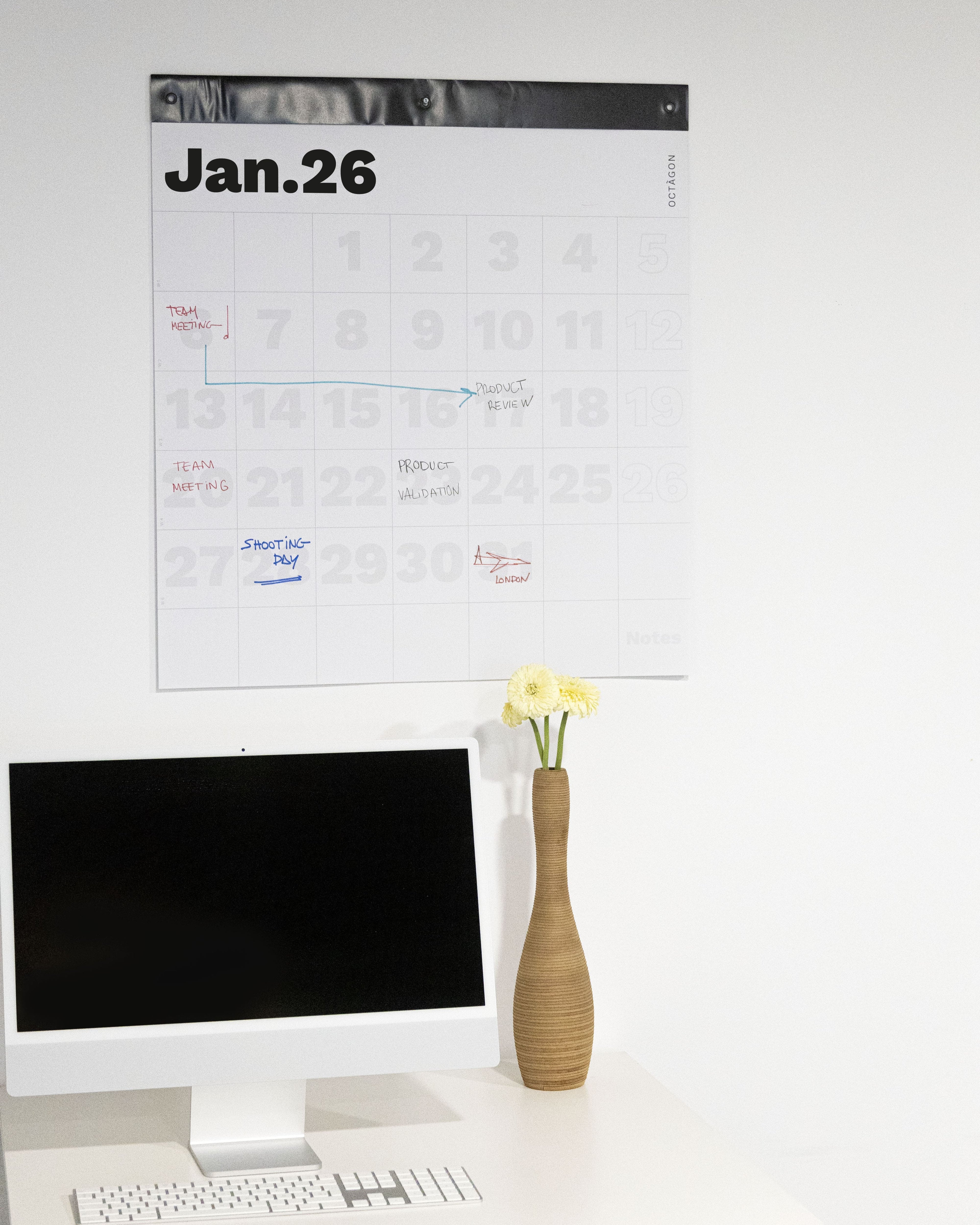 2026 Octàgon Design Giant Wall Planner on a white wall above a desk with a computer and vase.