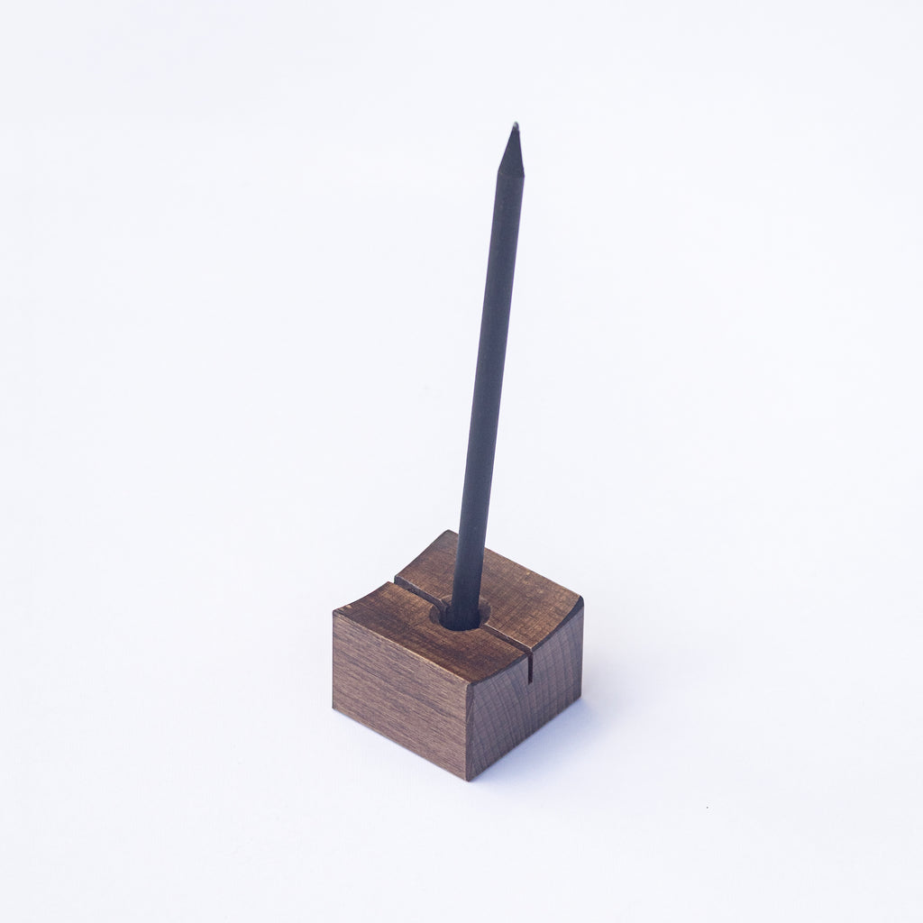 Min Point wooden pen holder with a black pen on a white background