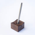 Min Point pencil holder with a metal pen on a white background