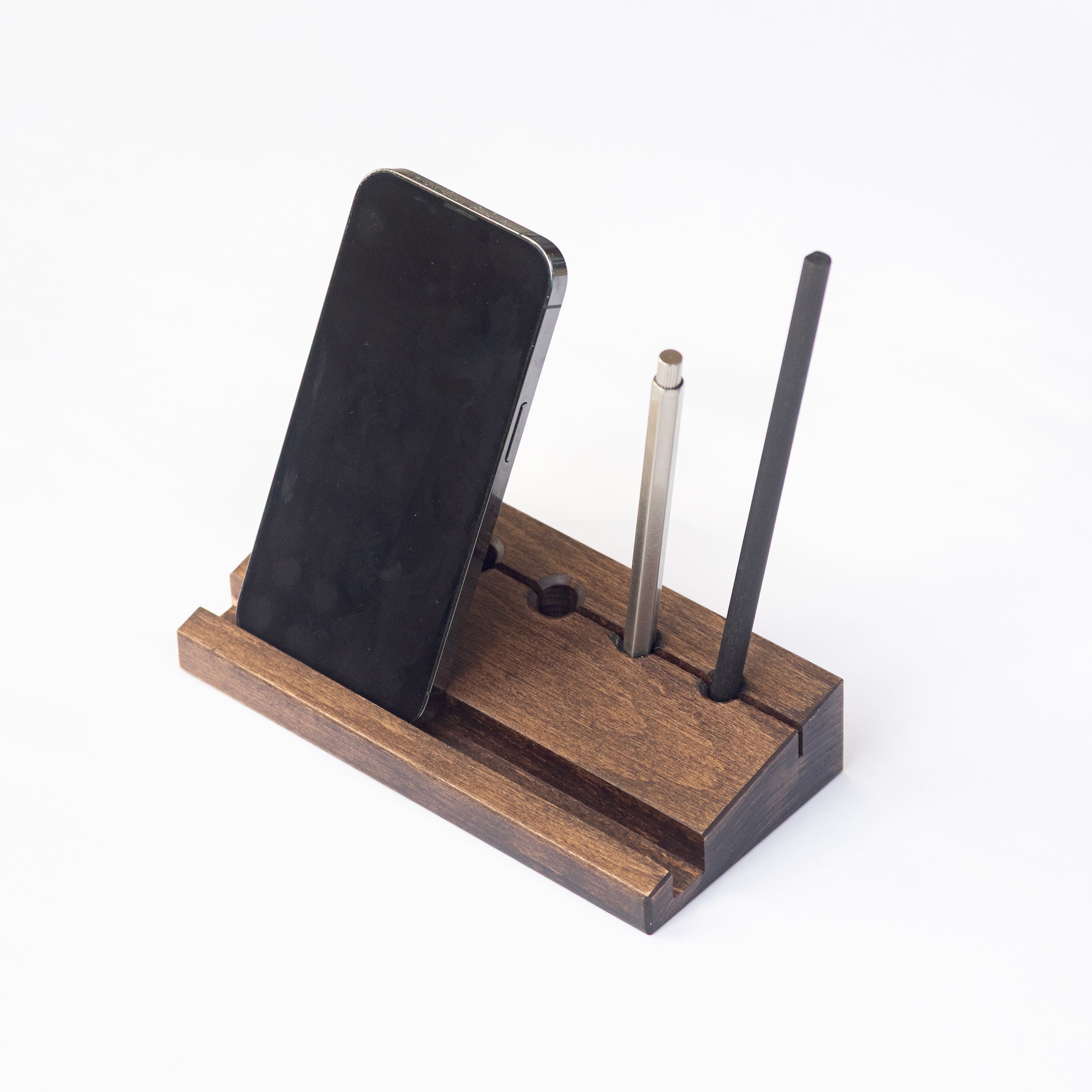 Min Prism wooden phone stand with smartphone, stylus, and pen on a white background