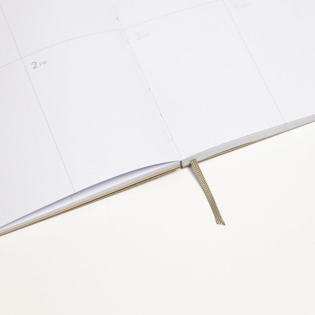2027 Weekly Planner A5 by Octàgon Design. Camel color. Exposed spine detail.