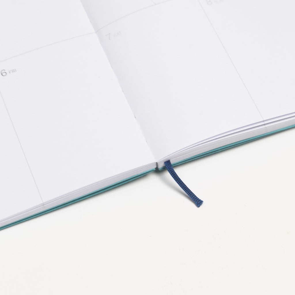 2027 Weekly Planner A5 by Octàgon Design. Caribbean Blue color. Exposed spine detail.