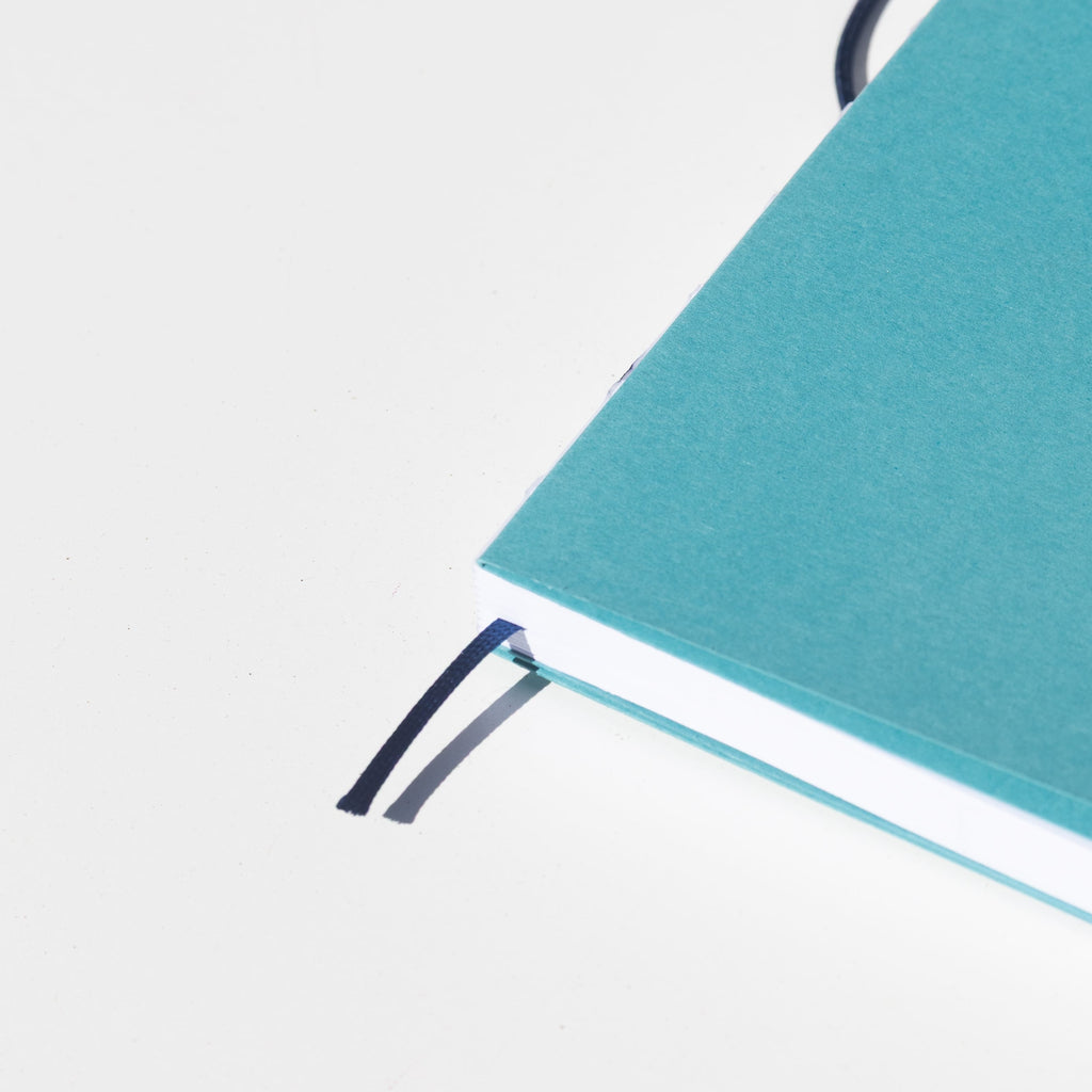 2027 Weekly Planner A5 by Octàgon Design. Caribbean Blue color. Exposed spine detail.