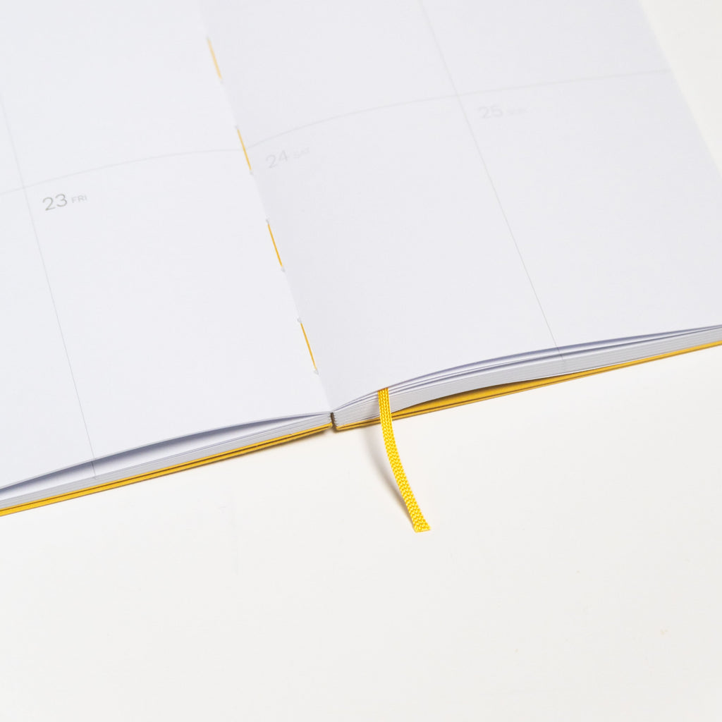 2027 Weekly Planner A5 by Octàgon Design. Yellow color. Exposed spine detail.
