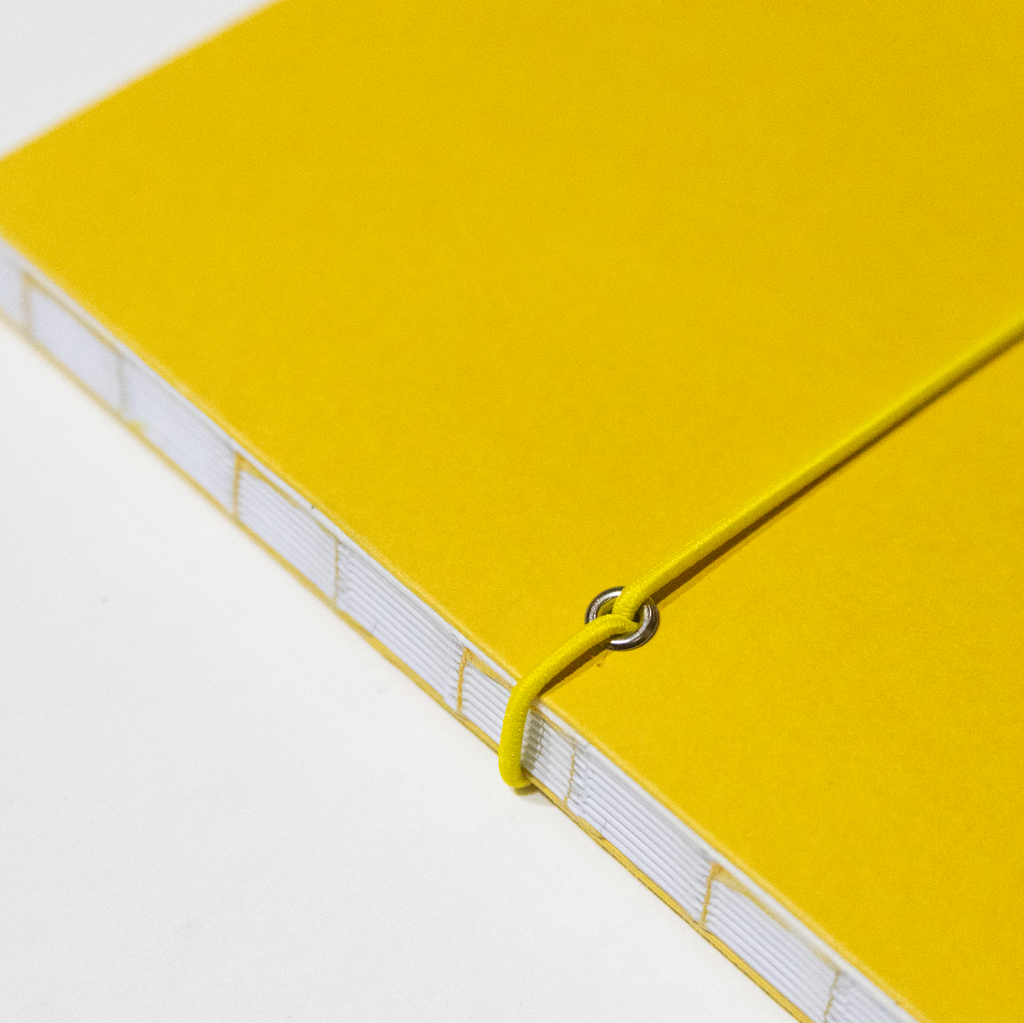 2027 Weekly Planner A5 by Octàgon Design. Yellow color. Exposed spine detail.