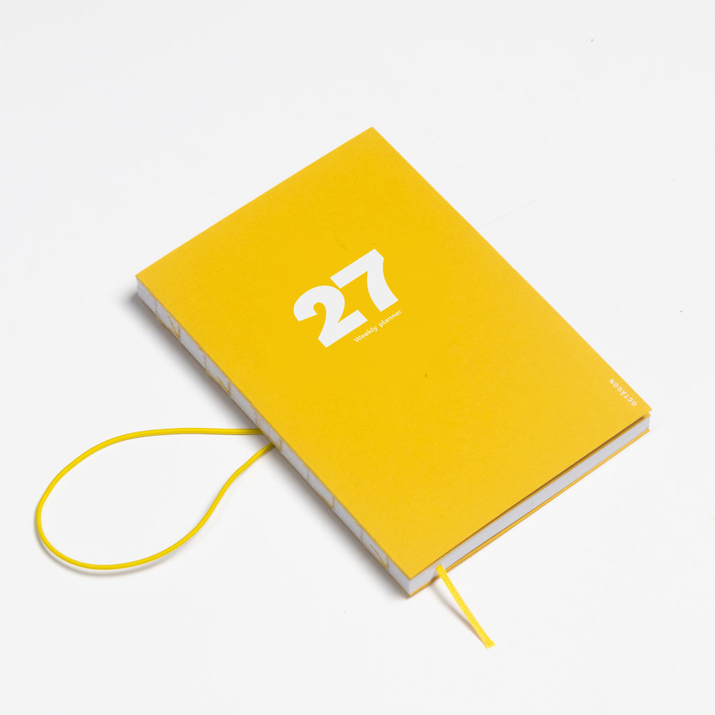 2027 Weekly Planner A5 by Octàgon Design. Indian Yellow color. Elastic band detail.