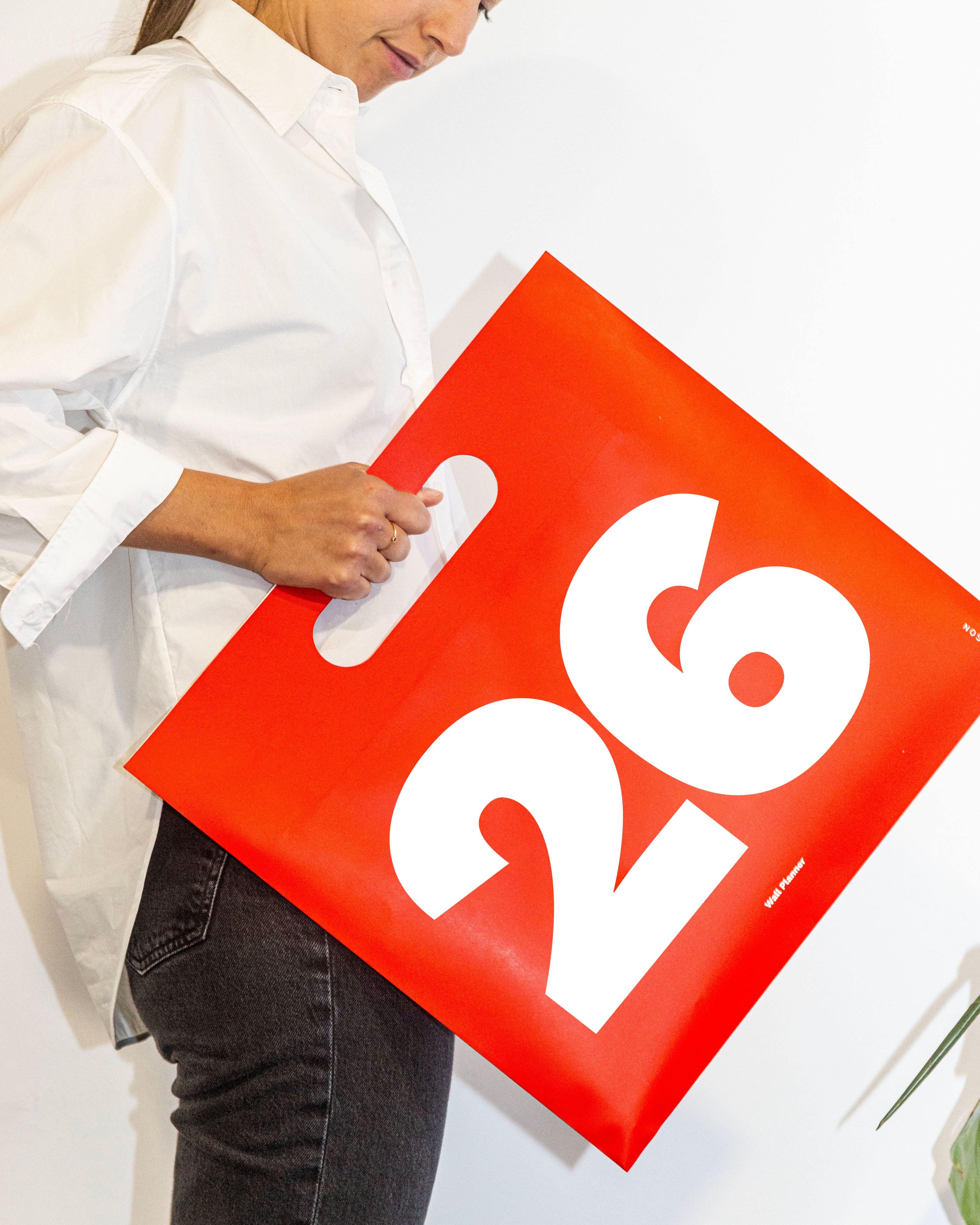 Person holding a 2026 Octàgon Design Wall Planner A3