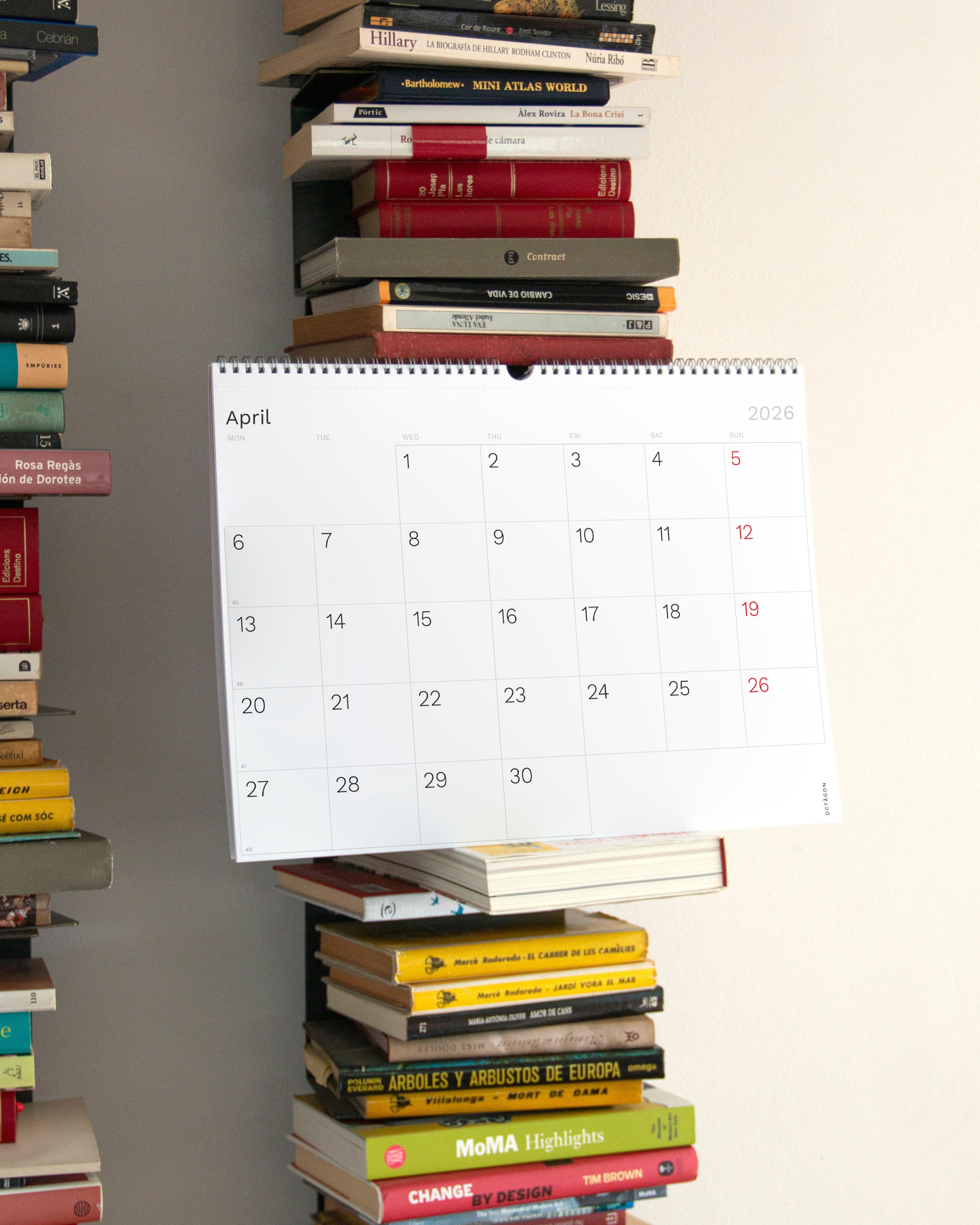 2026 Octàgon Design Wall Planner A3 on a stack of books with a neutral background 