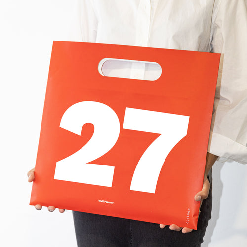 2027 Wall Planner by Octàgon Design. A girl showing the calendar bag.
