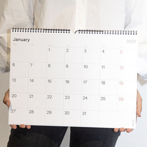 2027 Wall Planner by Octàgon Design. A girl showing the calendar page of January. 