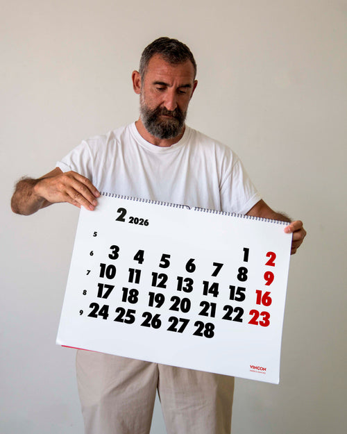 Man holding a 2026 Vinçon Wall Calendar from Octàgon Design with a plain background
