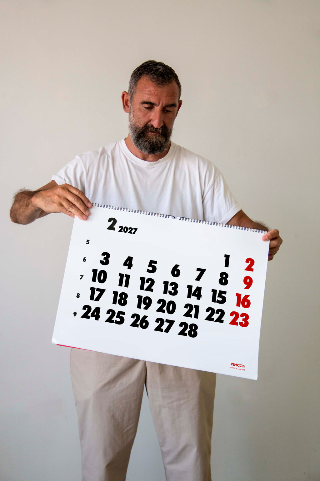 2027 Vinçon wall Calendar by Octàgon Design. A man holding the Vinçon Calendar.