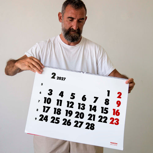 2027 Vinçon wall Calendar by Octàgon Design. A man holding the Vinçon Calendar.