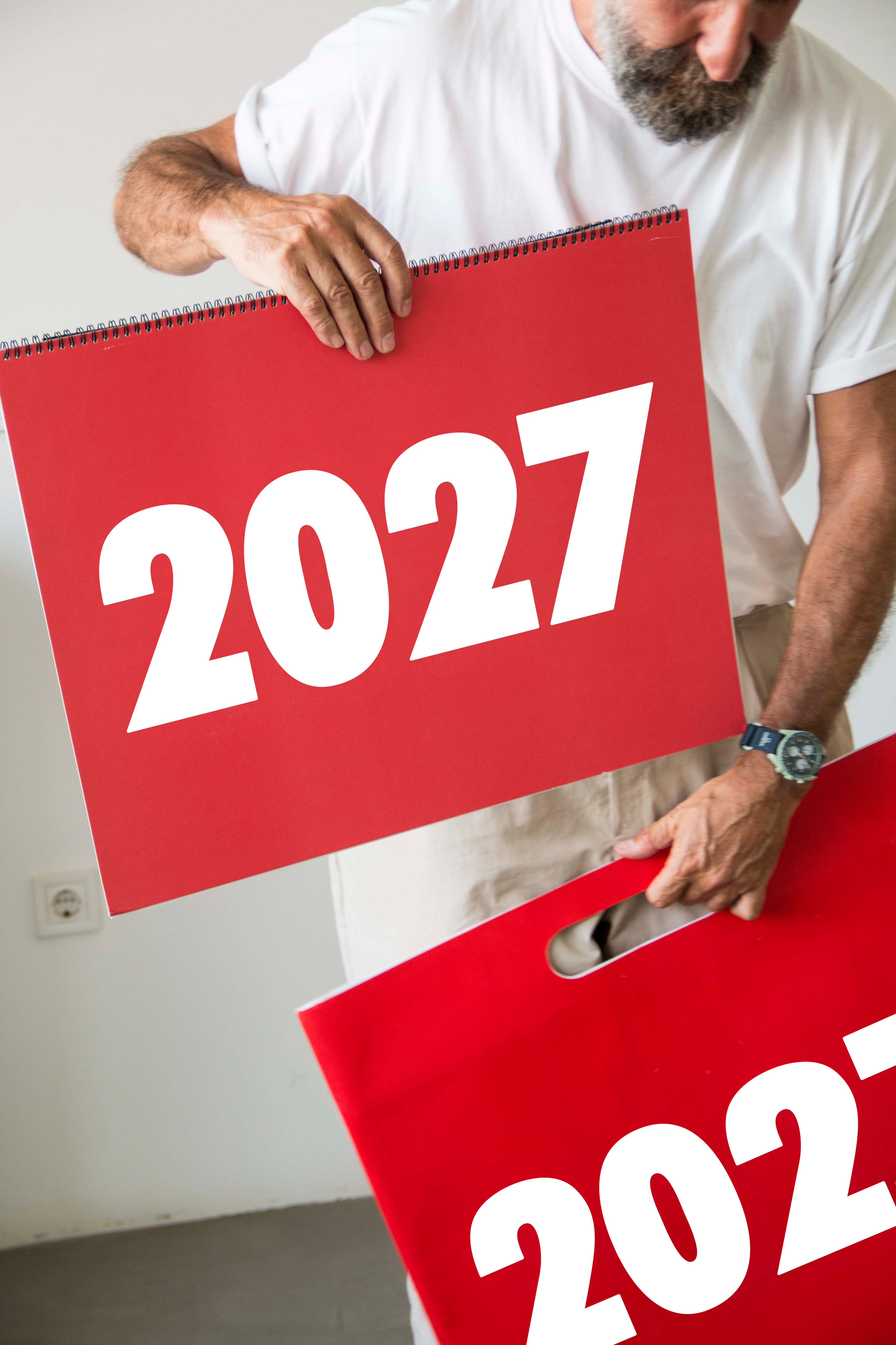 2027 Vinçon wall Calendar by Octàgon Design. A man putting de calendar in his bag.