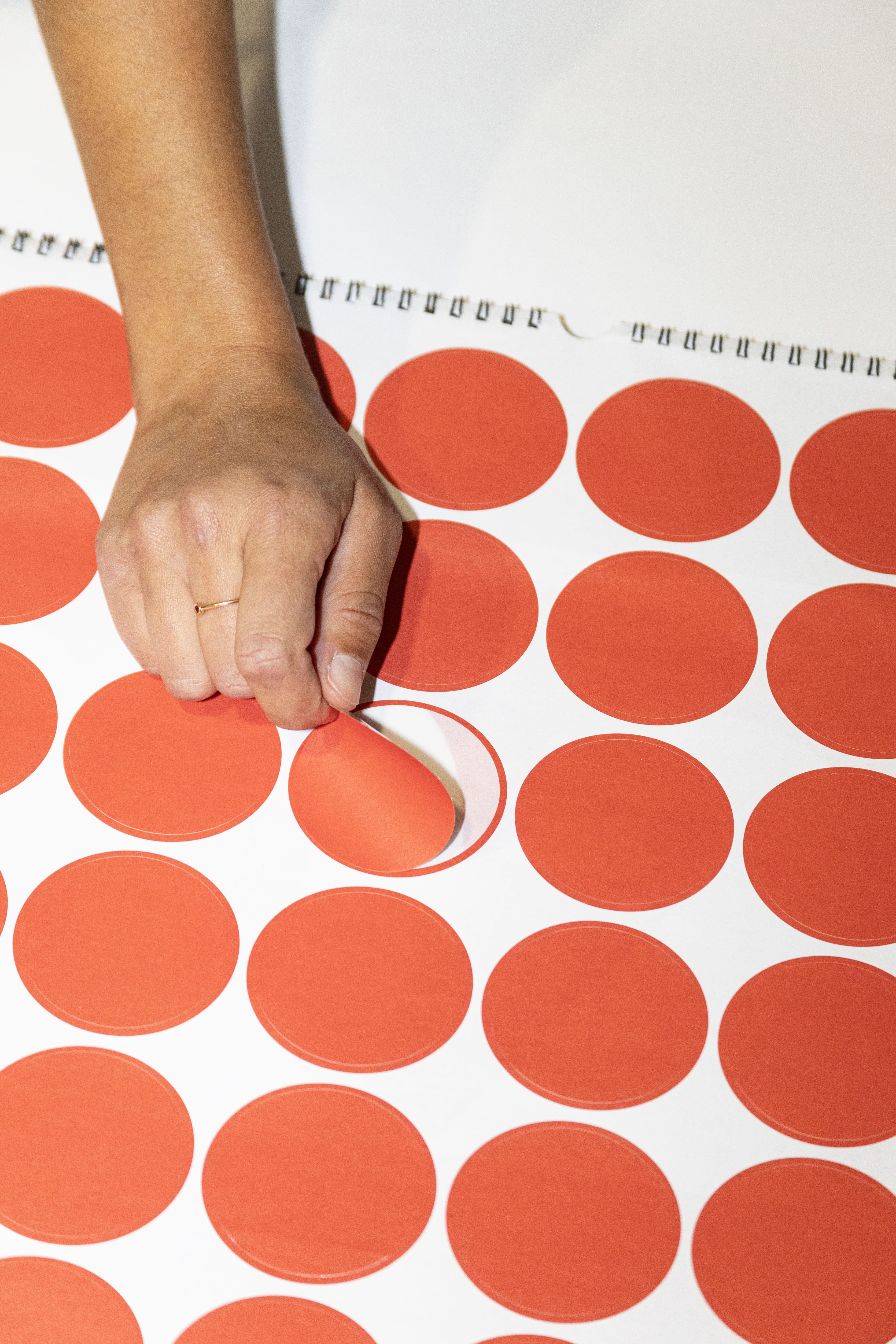 2027 Vinçon wall Calendar by Octàgon Design. Page with round red stickers so you can mark local holidays or personal dates.