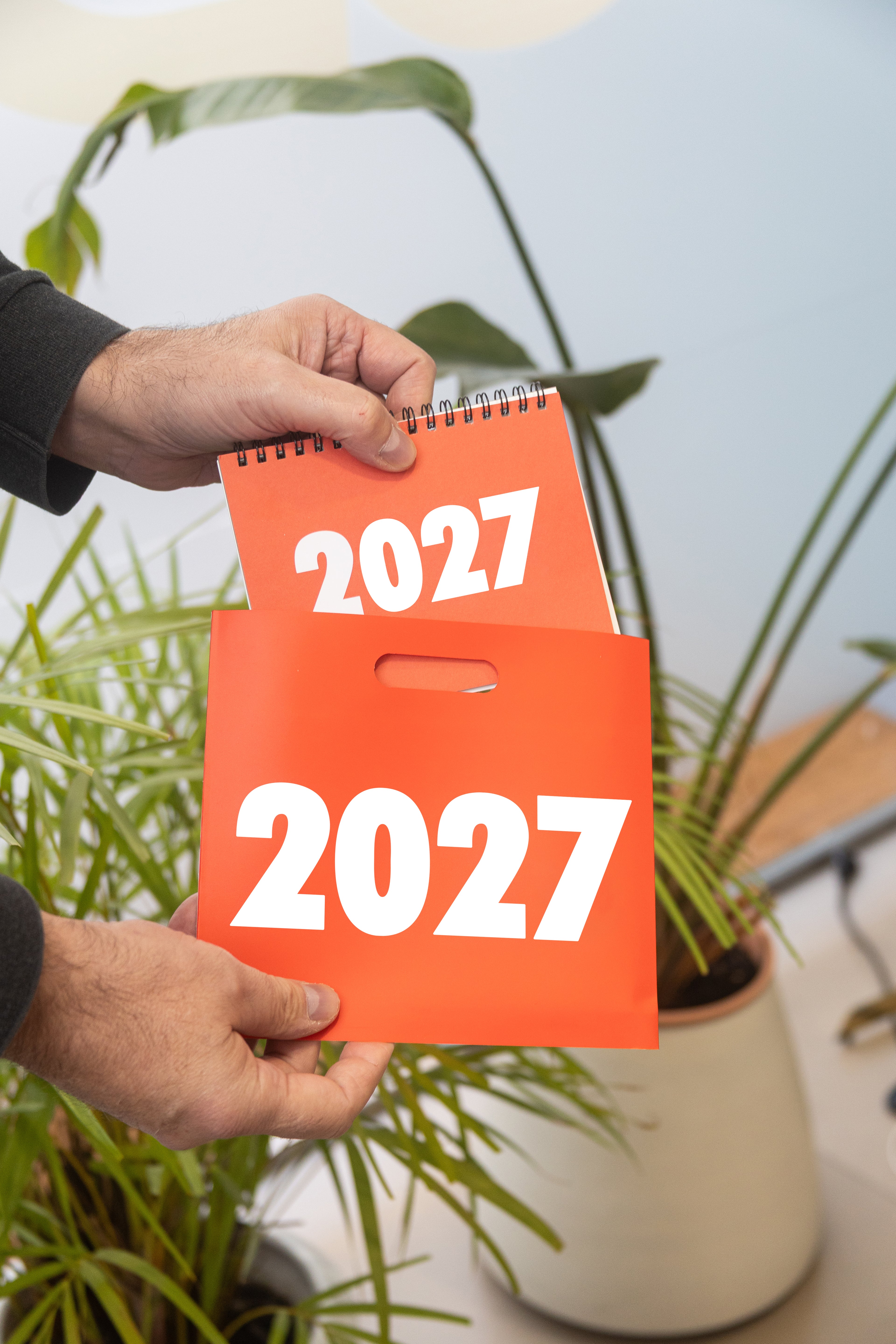 2027 Vinçon desk calendar by Octàgon Design. A man holding the calendar and his little bag.