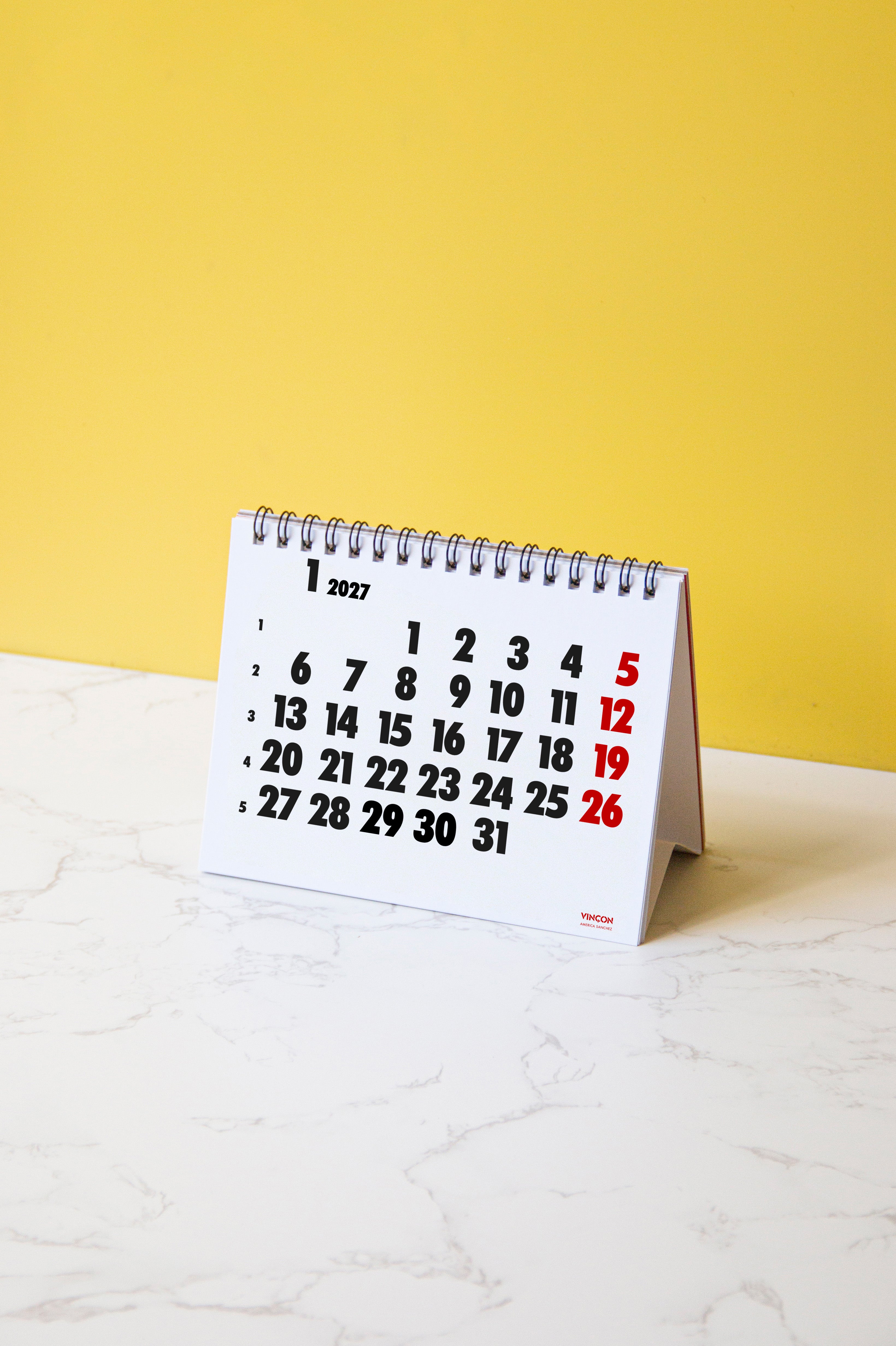 2027 Vinçon desk calendar by Octàgon Design. The calendar on a table.