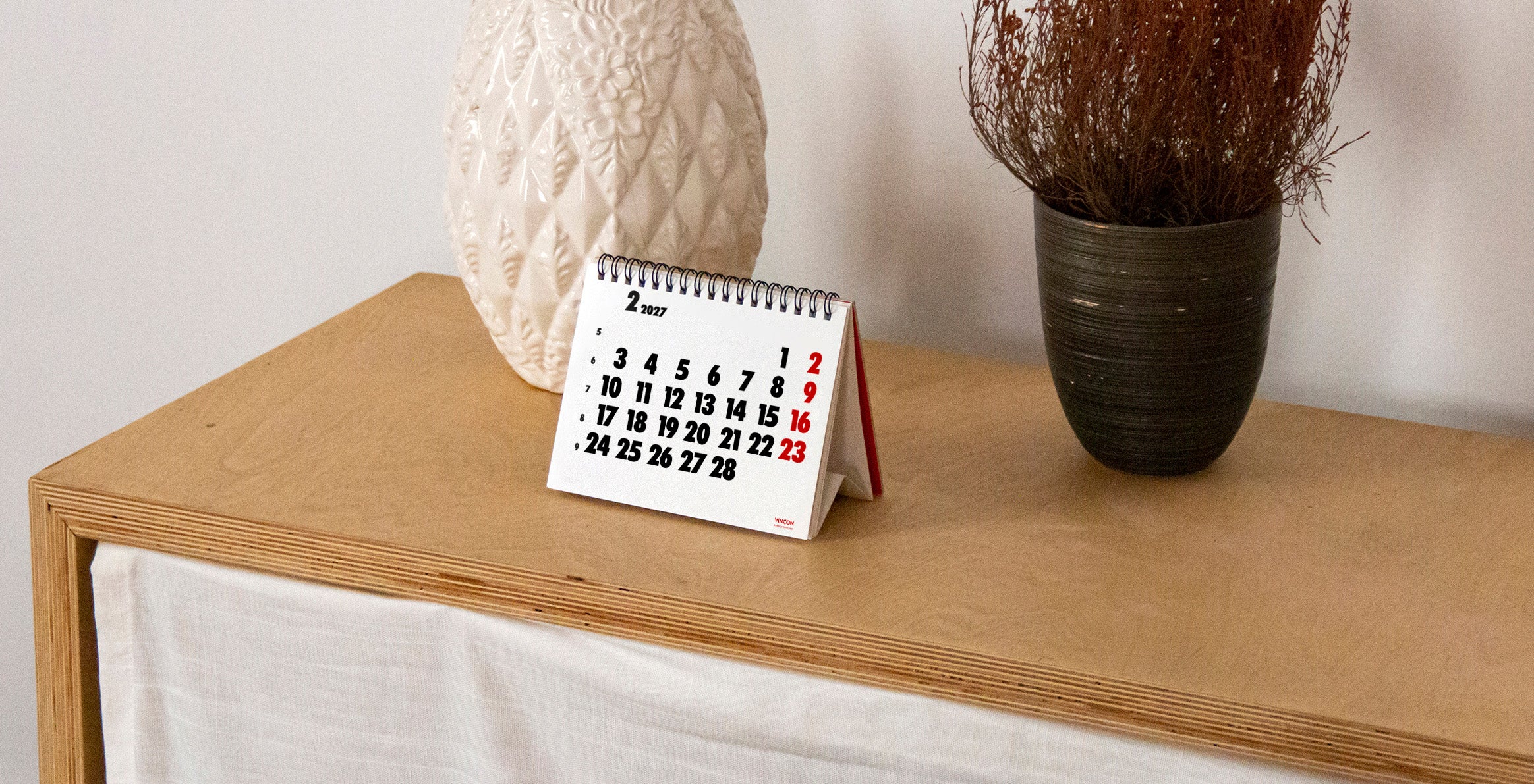 2027 Vinçon desk calendar by Octàgon Design. The calendar on a shelf.