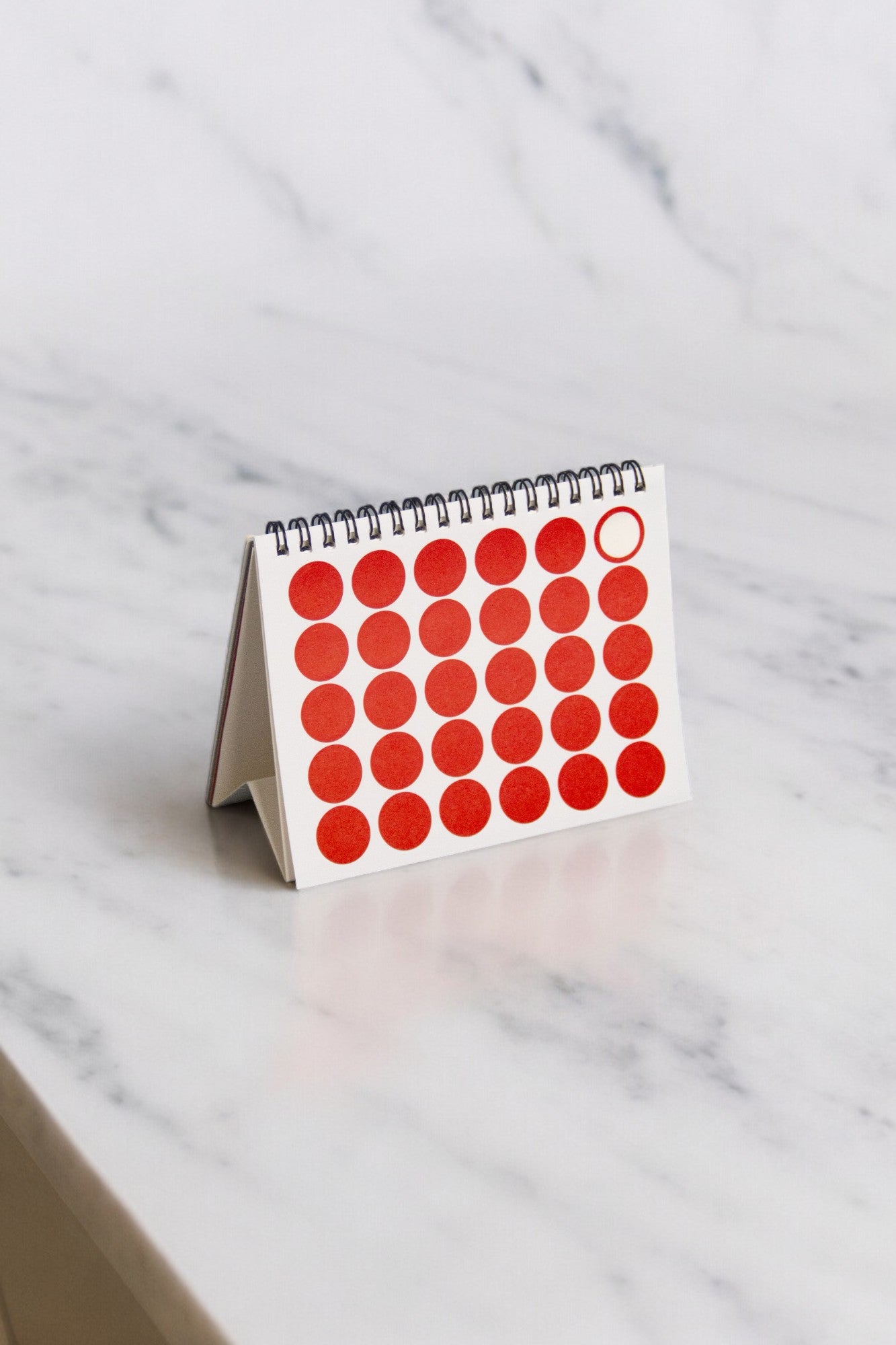 2027 Vinçon desk calendar by Octàgon Design. The calendar on a table showing the page of the date markers.