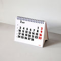2027 Vinçon desk calendar by Octàgon Design. The desk calendar on a table.