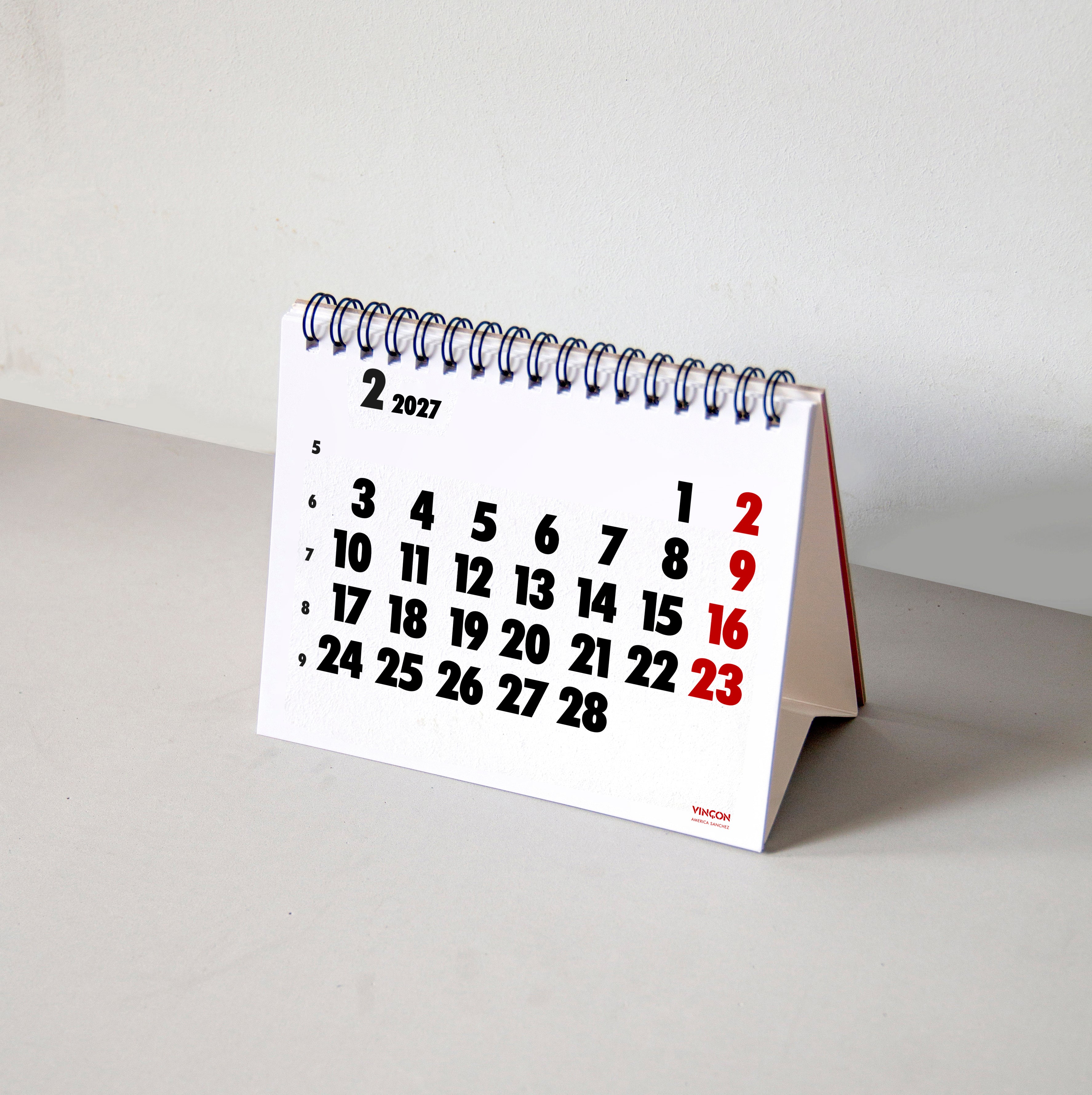 2027 Vinçon desk calendar by Octàgon Design. The desk calendar on a table.