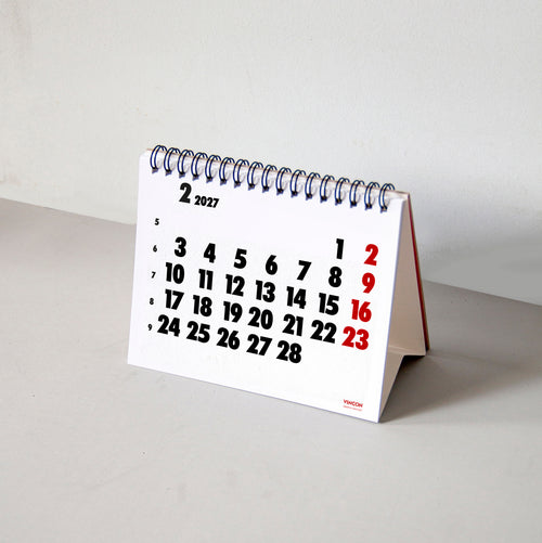 2027 Vinçon desk calendar by Octàgon Design. The desk calendar on a table.