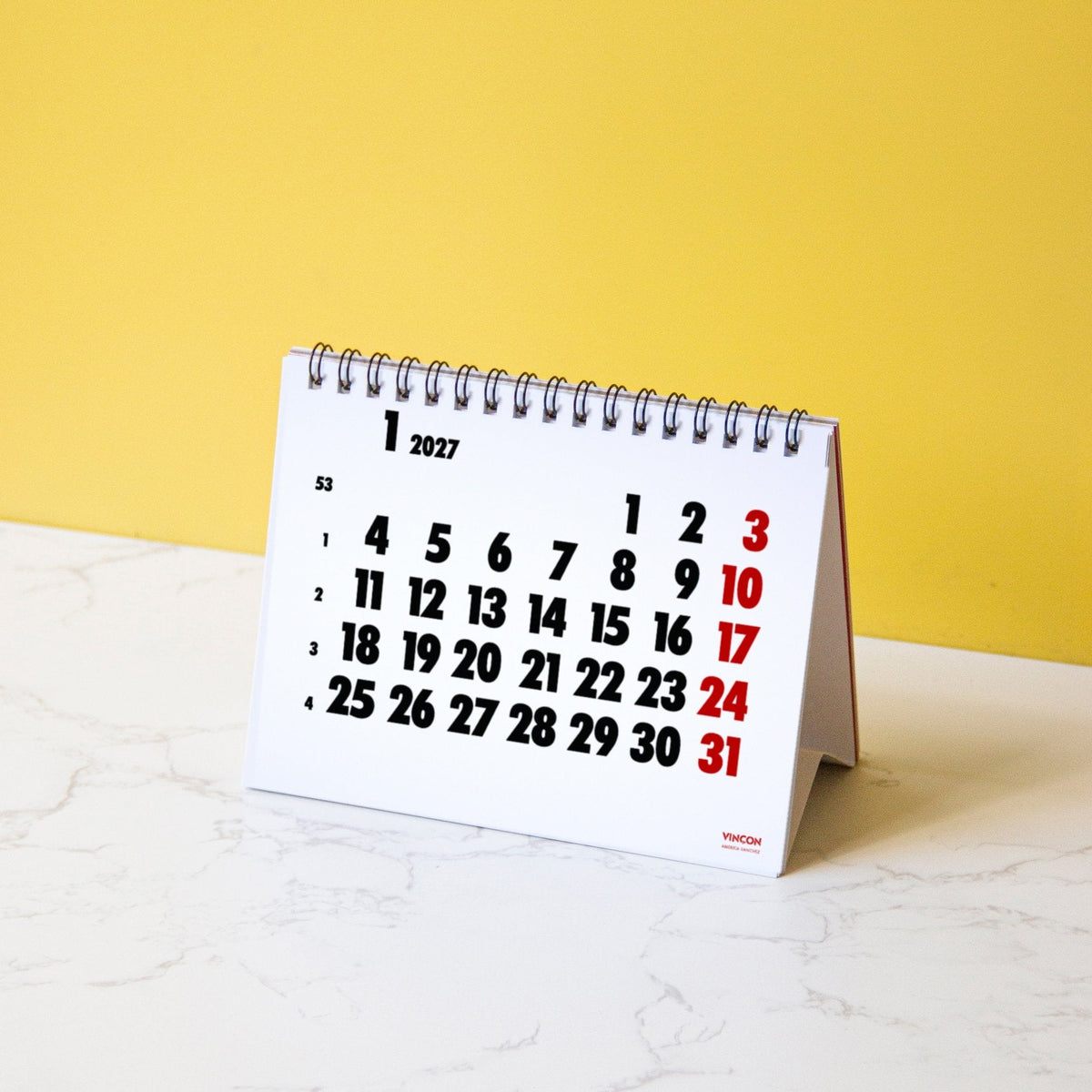 2027 Vinçon desk calendar by Octàgon Design. The calendar on a table.