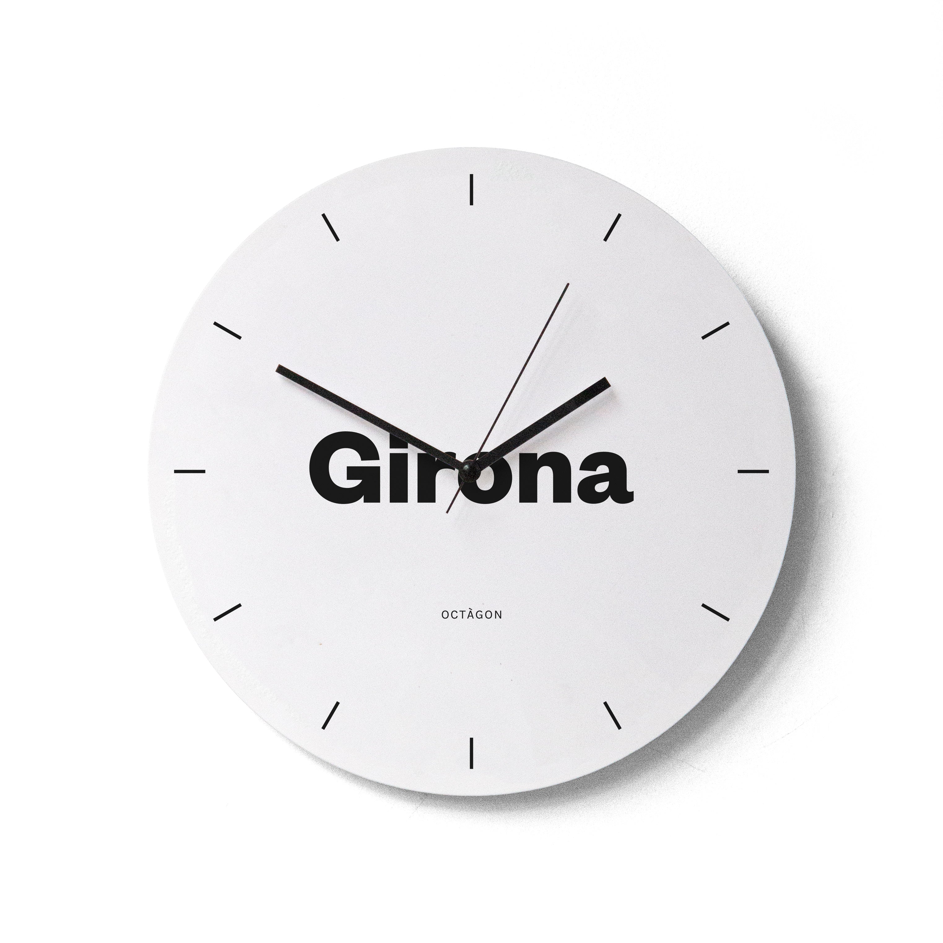 "Girona" wall clock. White base, typography and clock hands black colour.