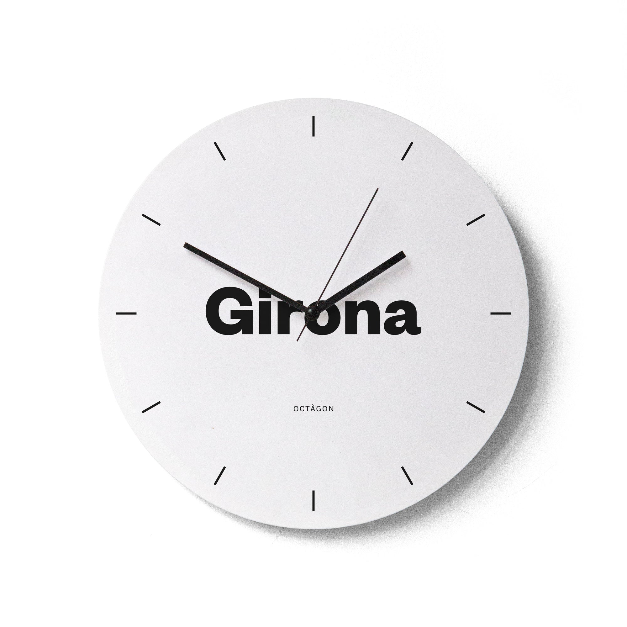 "Girona" wall clock. White base, typography and clock hands black colour.