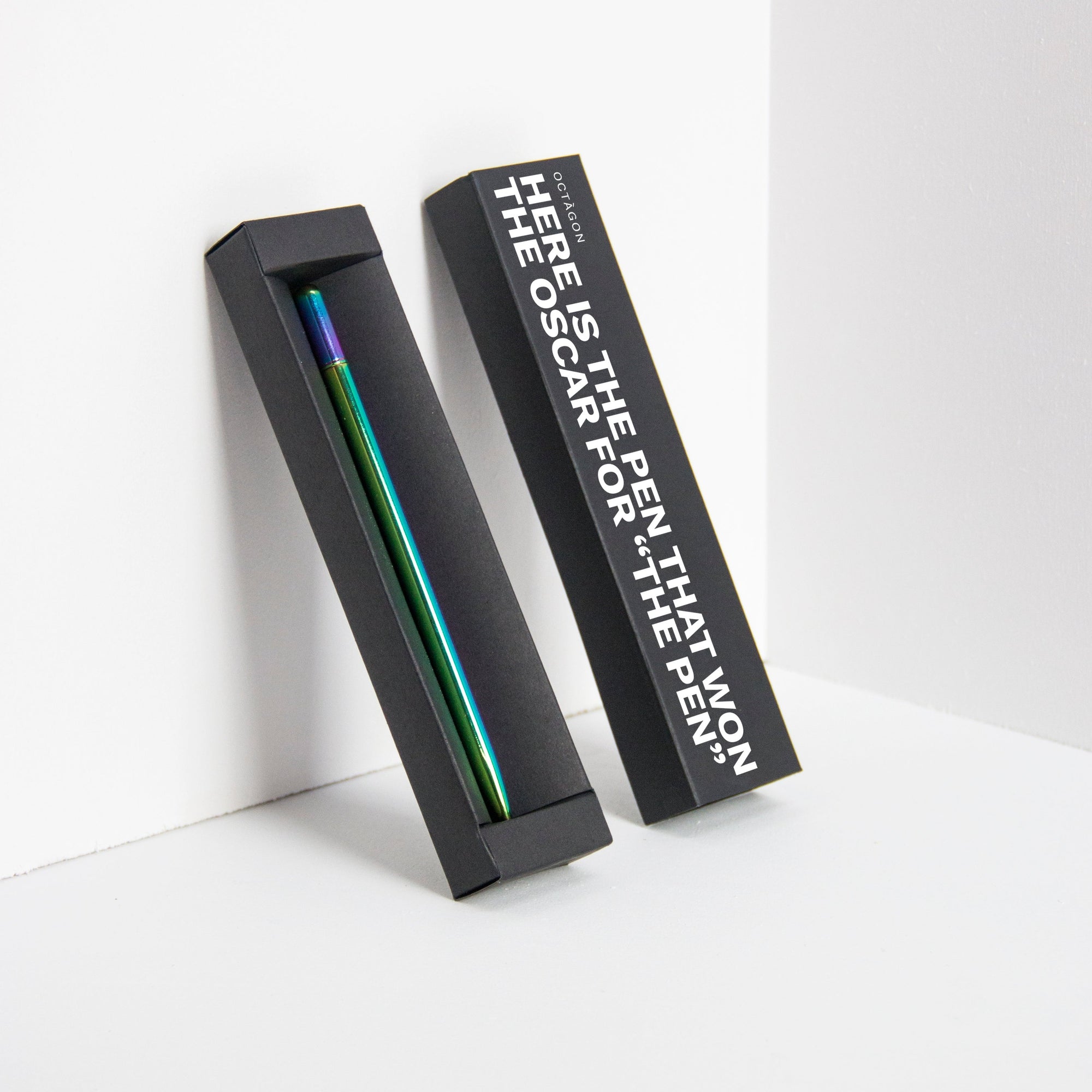 OCTÀGON DESIGN | "Drop Pen" metallic rainbow color pen and black pen box with "Here is the pen that won the Oscar for "THE PEN" print white colour.