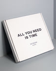 White clock box with "All you need is time" print black colour. 