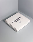 Box with "All you need is time" print leaning on a gray wall | Caja estampada "All ypu need is time" sobre una pared gris. | Caixa estampada "All you need is time" sobre una paret gris.
