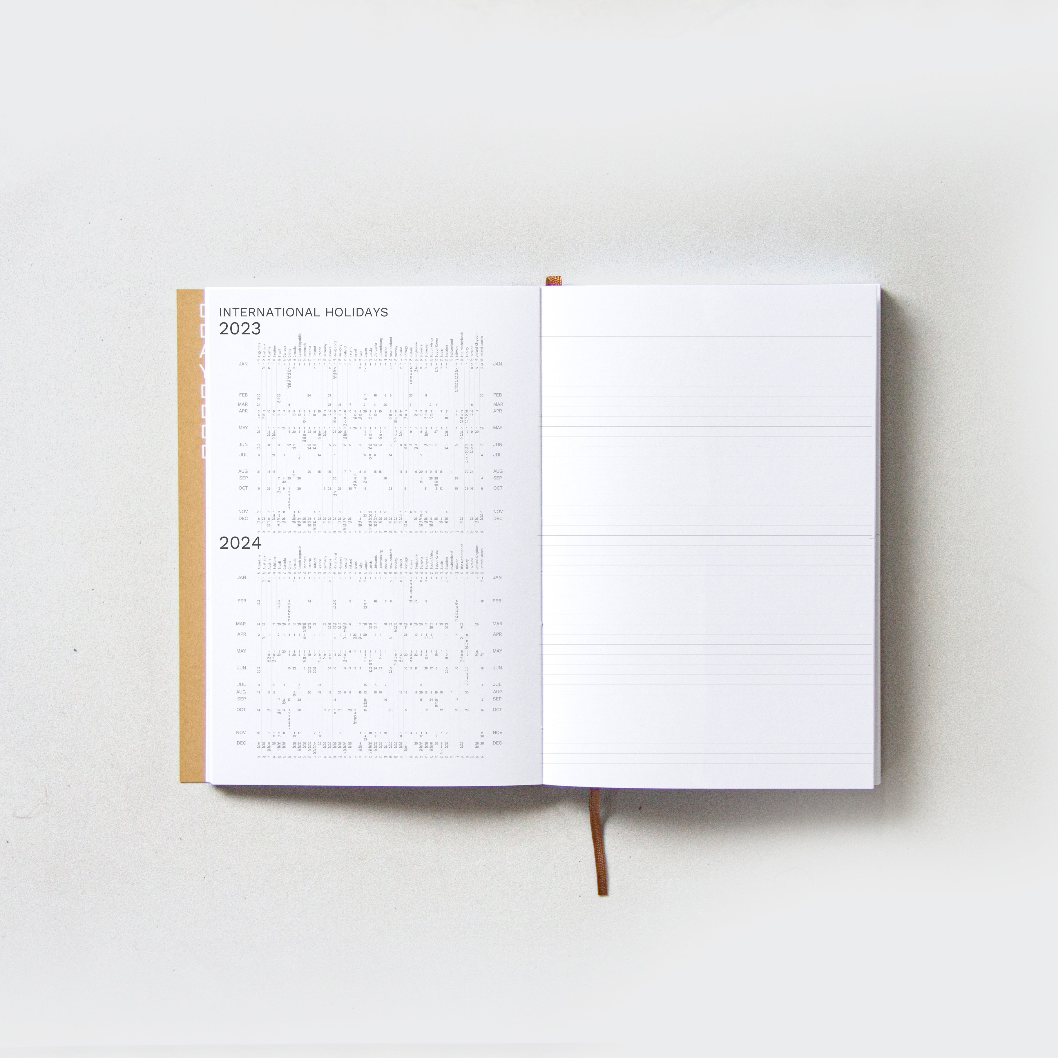 OCTÀGON DESIGN, Open &quot;Sep23 to Aug24&quot; Academic weekly planner. International holidays 2023 and 2024 on the left page and a lined template for notes on the right page.