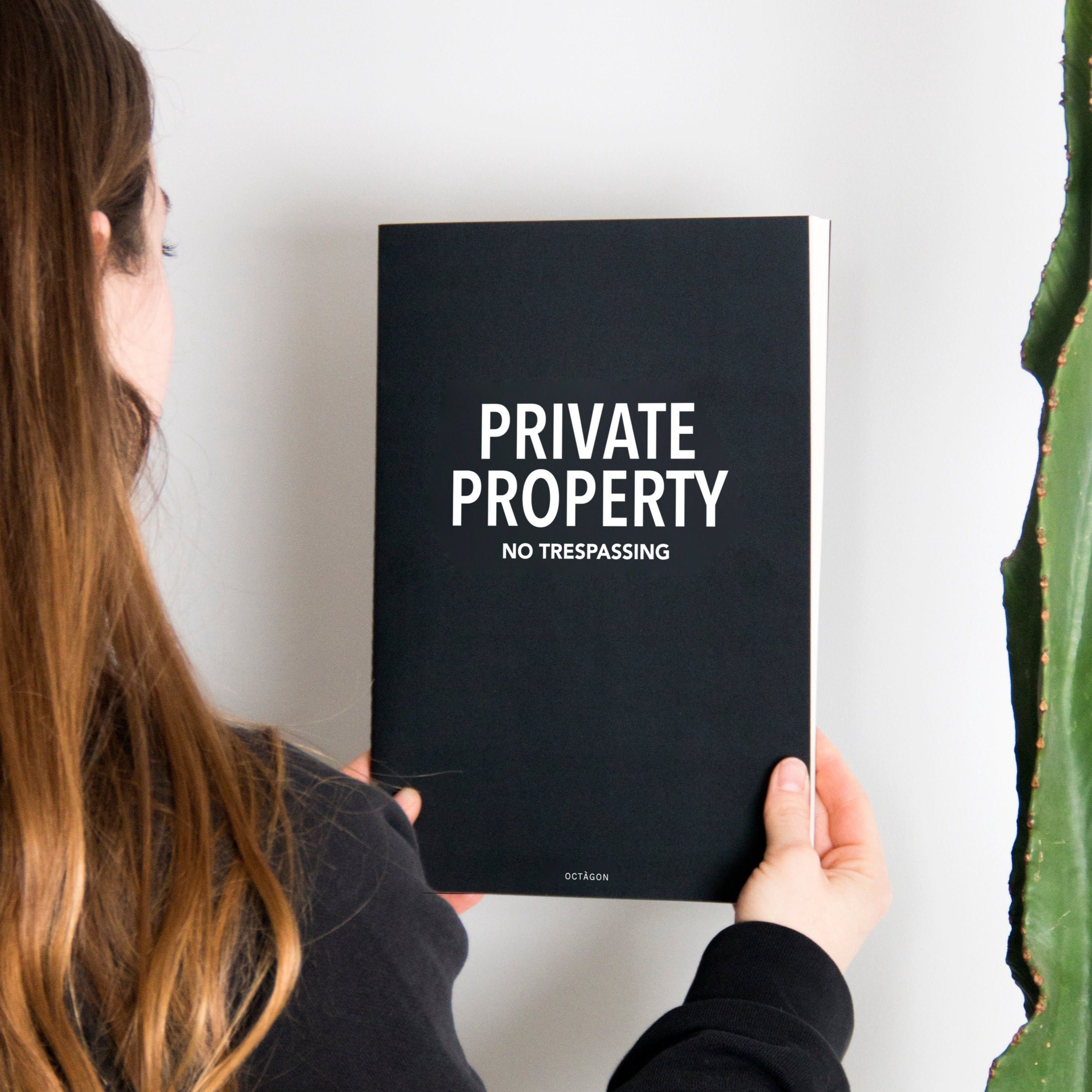 "Private property" thin notebook. Cover black color and white typography.